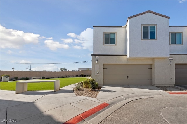 townhome / multi-family property with a garage, concrete driveway, a front yard, and stucco siding