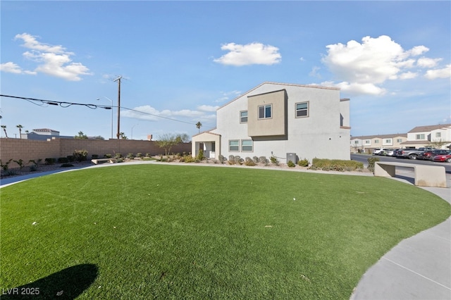 view of front of property featuring a front yard, fence, and stucco siding