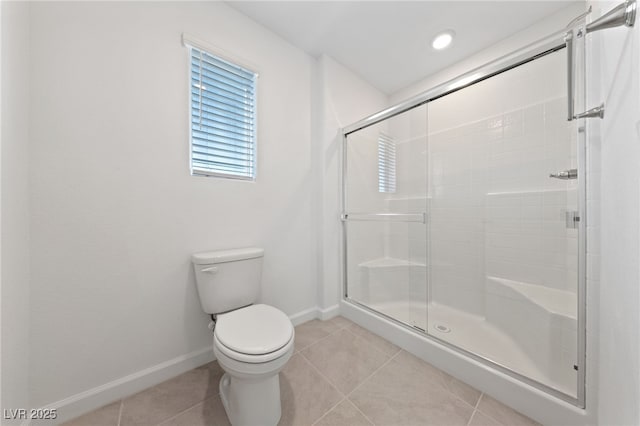 bathroom with toilet, a stall shower, baseboards, and tile patterned floors