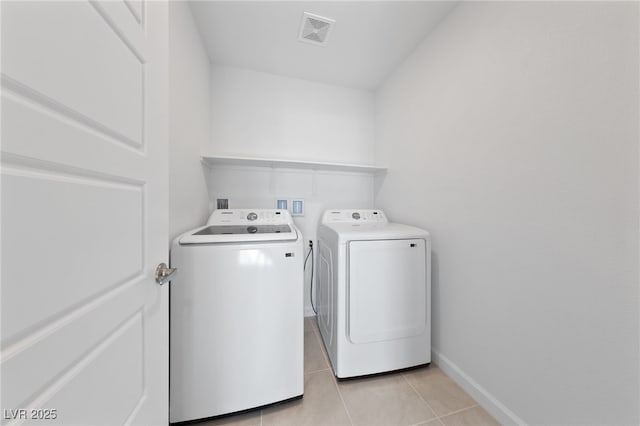 laundry area featuring light tile patterned floors, laundry area, separate washer and dryer, visible vents, and baseboards