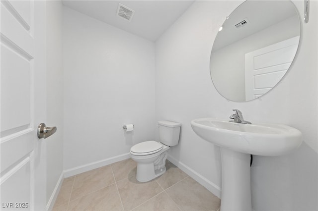 bathroom featuring toilet, baseboards, visible vents, and tile patterned floors