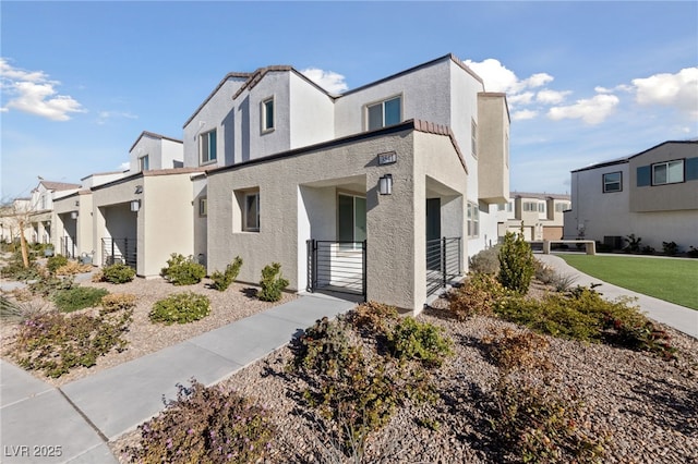 view of side of property with a residential view, a gate, and stucco siding