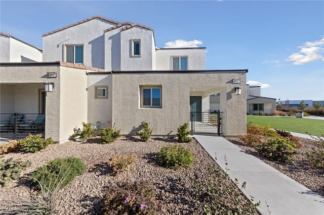 view of front of home with a gate and stucco siding