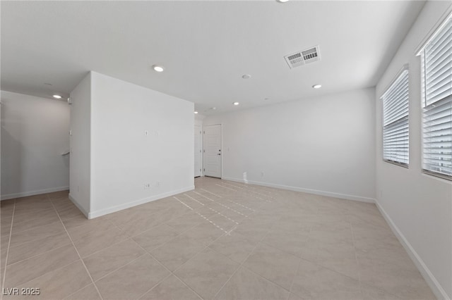 spare room featuring light tile patterned floors, baseboards, visible vents, and recessed lighting