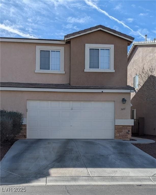 traditional home with driveway, stone siding, an attached garage, and stucco siding