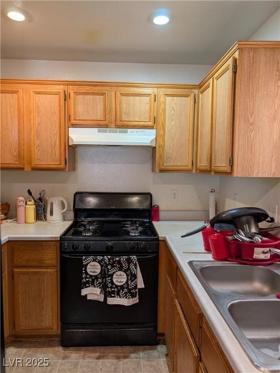 kitchen with recessed lighting, light countertops, black gas stove, a sink, and under cabinet range hood