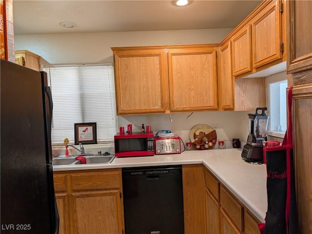 kitchen featuring black appliances, a sink, light countertops, and recessed lighting