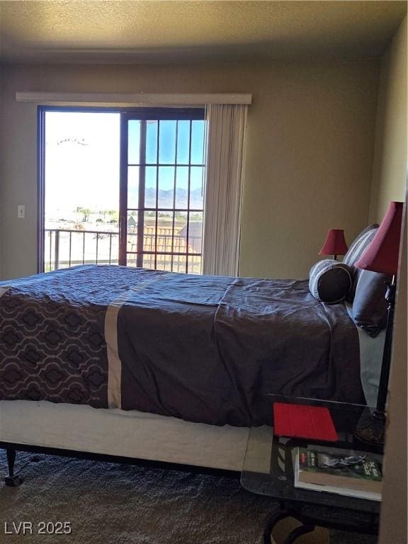 carpeted bedroom with access to outside and a textured ceiling