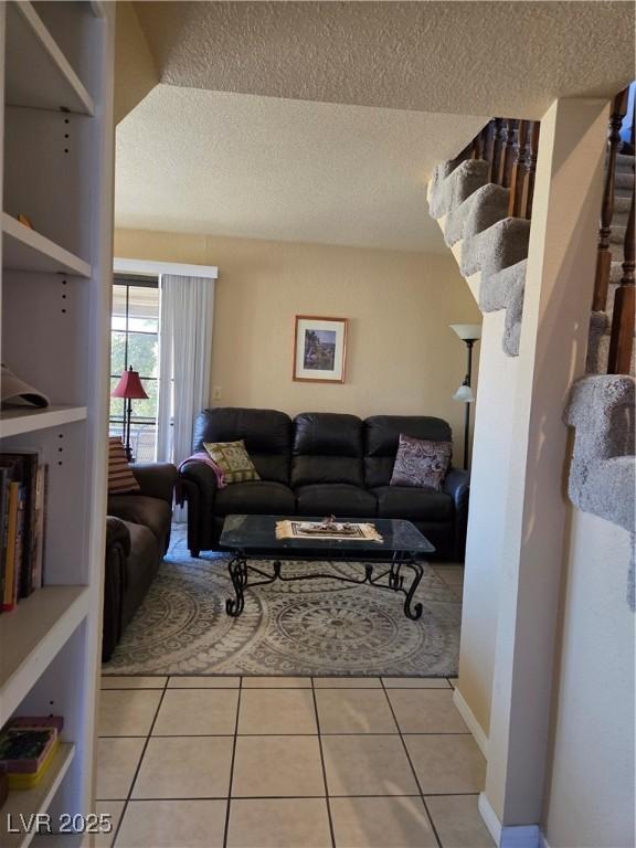 living room with a textured ceiling and light tile patterned flooring