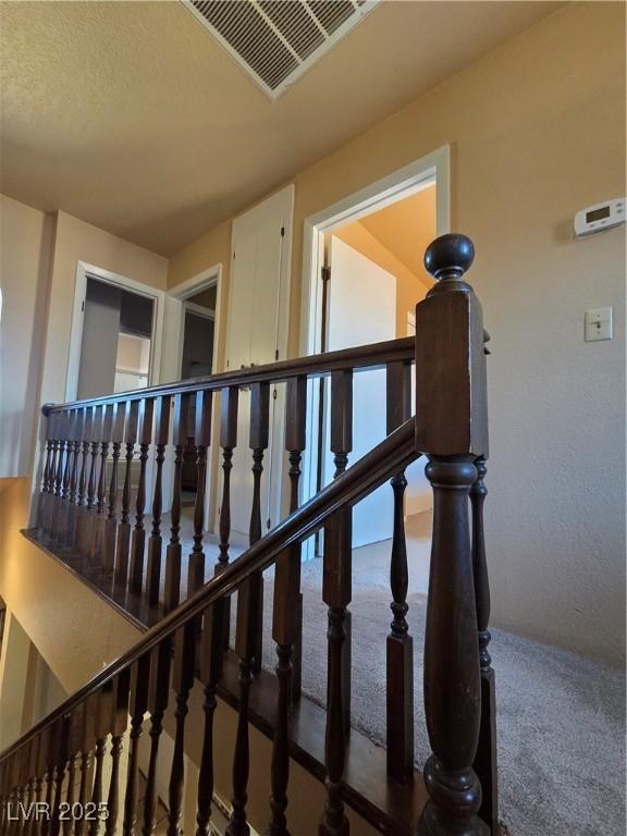 staircase with carpet and visible vents