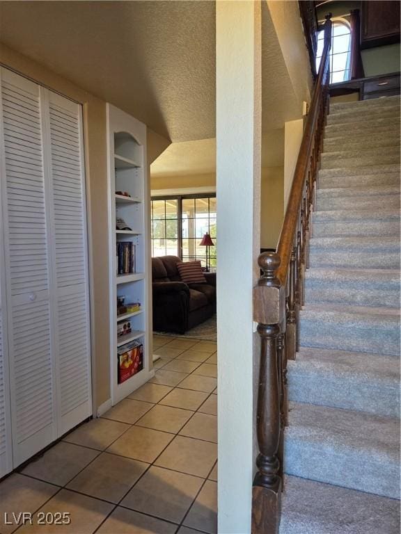 staircase featuring tile patterned flooring and built in shelves