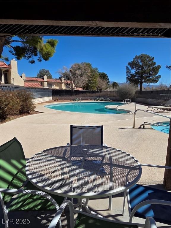 pool with outdoor dining area, a patio area, and a fenced backyard