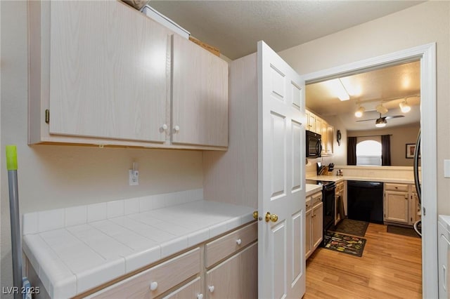 kitchen featuring black appliances, a textured ceiling, light wood finished floors, and a ceiling fan