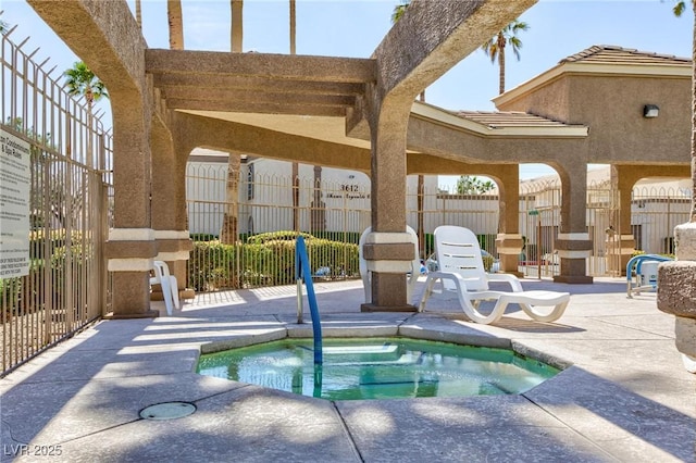 view of swimming pool featuring a hot tub, fence, and a patio