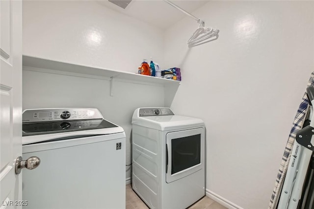 clothes washing area featuring laundry area, baseboards, and independent washer and dryer