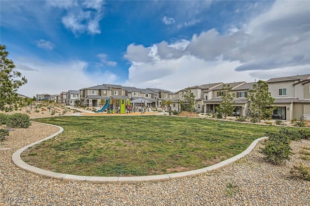 view of property's community with a residential view, playground community, and a lawn