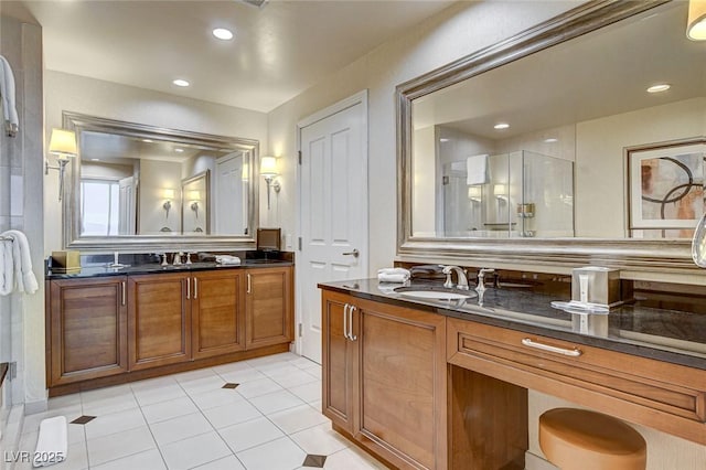 bathroom featuring recessed lighting, a stall shower, two vanities, and a sink