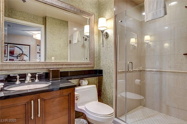 bathroom featuring a stall shower, toilet, and vanity