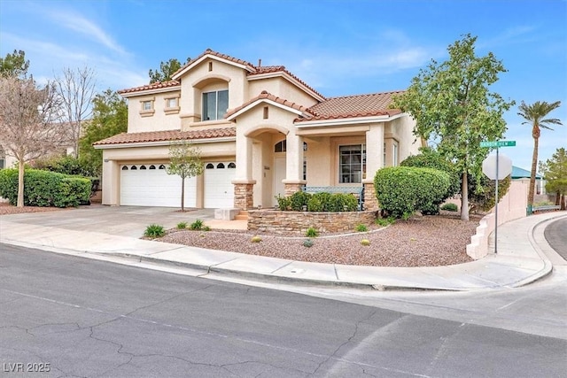 mediterranean / spanish-style home featuring driveway, an attached garage, a tile roof, and stucco siding