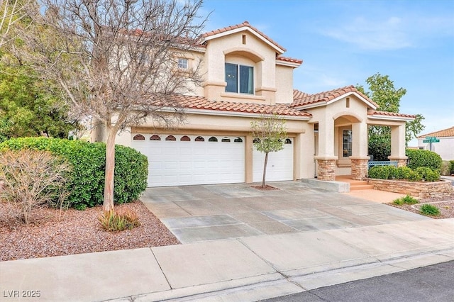 mediterranean / spanish home featuring driveway, a tiled roof, an attached garage, and stucco siding