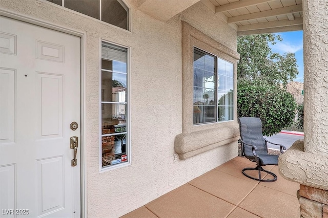 doorway to property featuring stucco siding