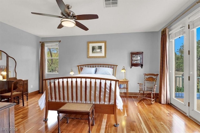 bedroom with baseboards, light wood-type flooring, visible vents, and access to exterior