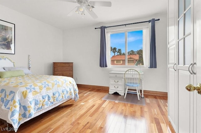 bedroom with light wood-type flooring, ceiling fan, and baseboards