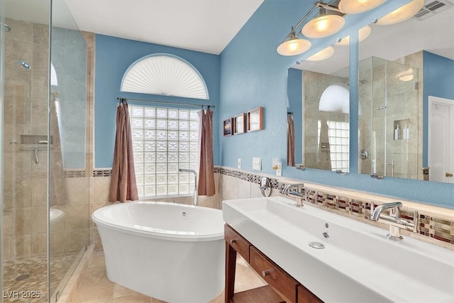 bathroom with a freestanding bath, a shower stall, and tile walls