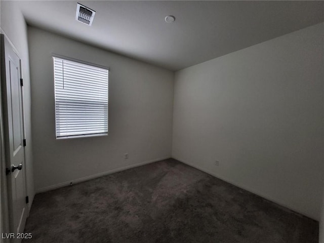 spare room featuring carpet, visible vents, and baseboards