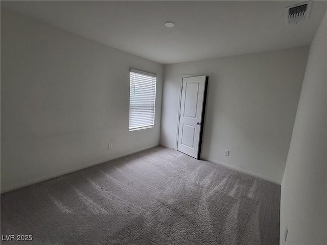 carpeted empty room with visible vents and baseboards