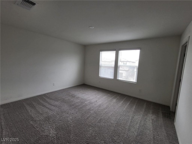 unfurnished room with carpet floors, visible vents, and baseboards