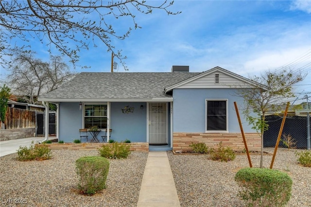 ranch-style house with a shingled roof, stone siding, fence, a porch, and stucco siding