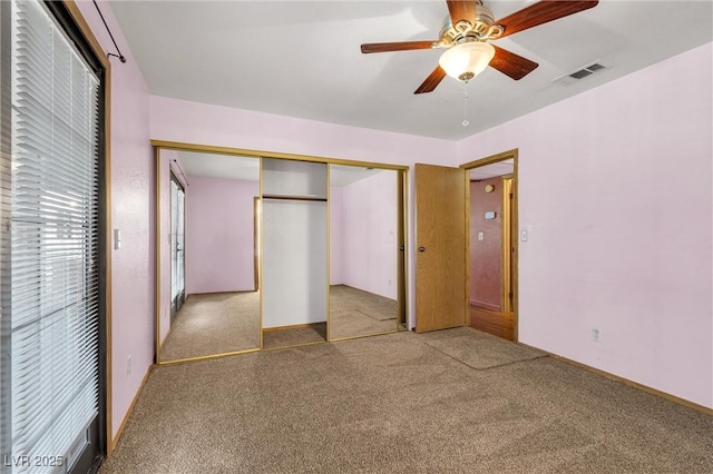 unfurnished bedroom featuring carpet floors, a closet, visible vents, and a ceiling fan