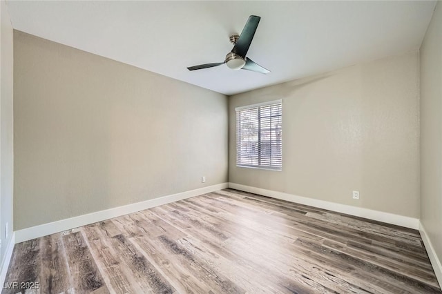 empty room with a ceiling fan, baseboards, and wood finished floors