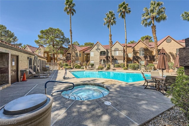 community pool featuring a hot tub, a residential view, fence, and a patio