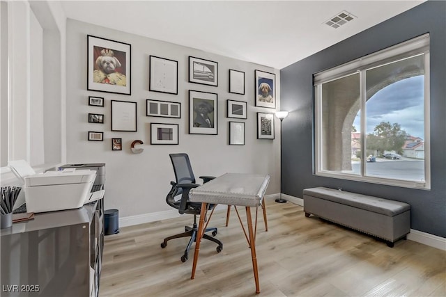 office with light wood-type flooring, visible vents, and baseboards