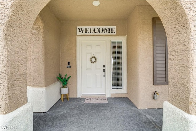 view of exterior entry featuring stucco siding