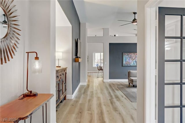 corridor with light wood-style flooring and baseboards