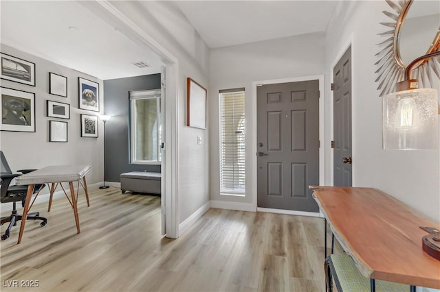 foyer featuring baseboards, visible vents, and light wood-style floors