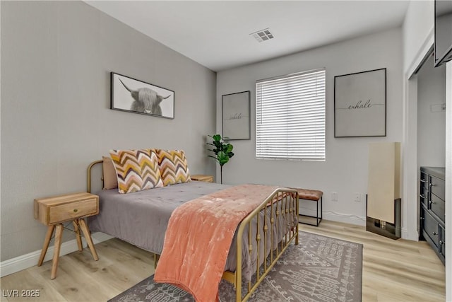 bedroom featuring light wood-type flooring, baseboards, and visible vents