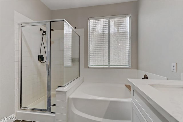 bathroom with a stall shower, a garden tub, and vanity