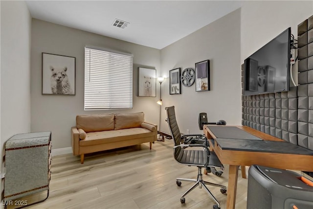 office space featuring wood finished floors, visible vents, and baseboards