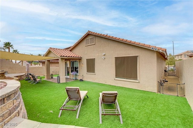 rear view of property with a yard, stucco siding, a patio area, a fenced backyard, and a tiled roof