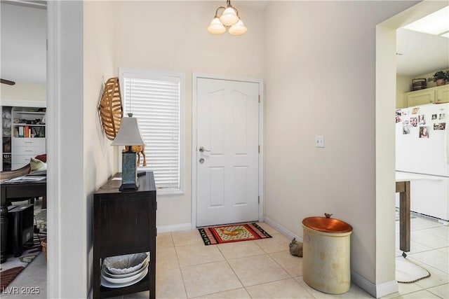 foyer with light tile patterned floors and baseboards