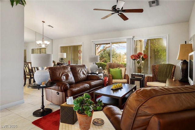 living area featuring lofted ceiling, light tile patterned floors, visible vents, and ceiling fan with notable chandelier