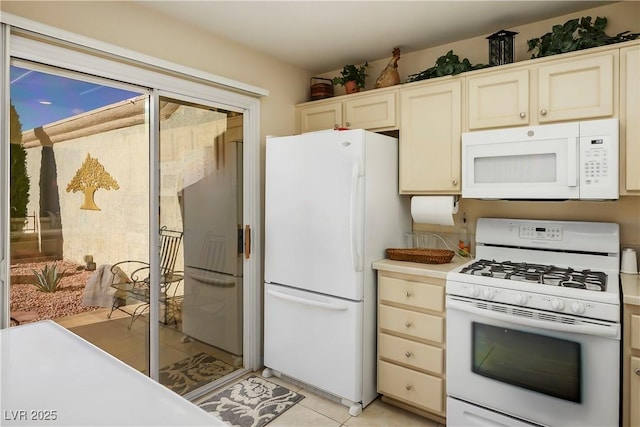 kitchen featuring light tile patterned floors, light countertops, and white appliances