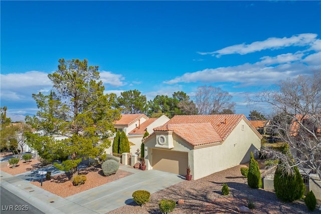 mediterranean / spanish-style house with concrete driveway, a tiled roof, an attached garage, and stucco siding