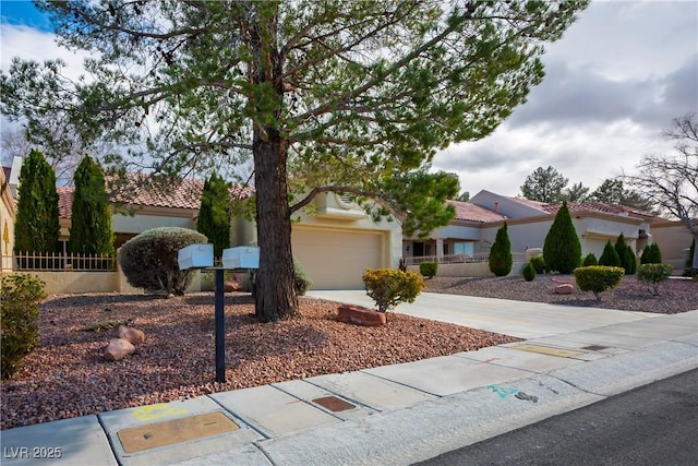 mediterranean / spanish home featuring a garage, driveway, a tiled roof, and stucco siding