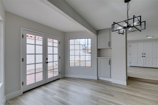 interior space featuring french doors, light wood-style floors, and baseboards