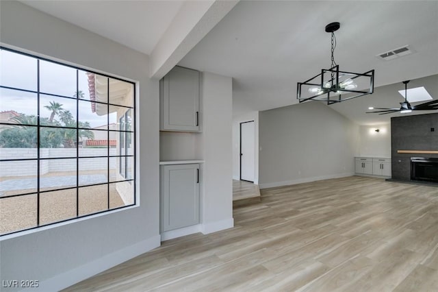 unfurnished living room featuring light wood-type flooring, visible vents, and baseboards